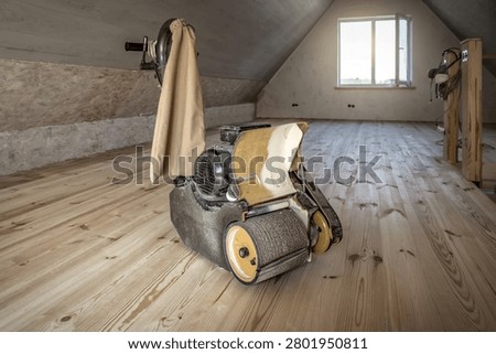 Professional drum floor sander machine on wooden flooring with copy space. Industrial theme