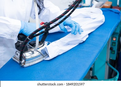 Professional Dry Cleaner Ironing A Customer's Shirt.Businesswoman And Small Business Concept.