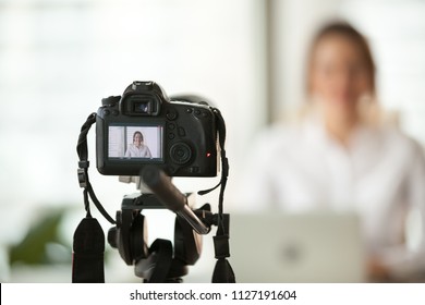 Professional dslr digital camera filming live video blog interview or vlog of woman vlogger coach giving business class or presentation training people online, making videoblog and vlogging concept