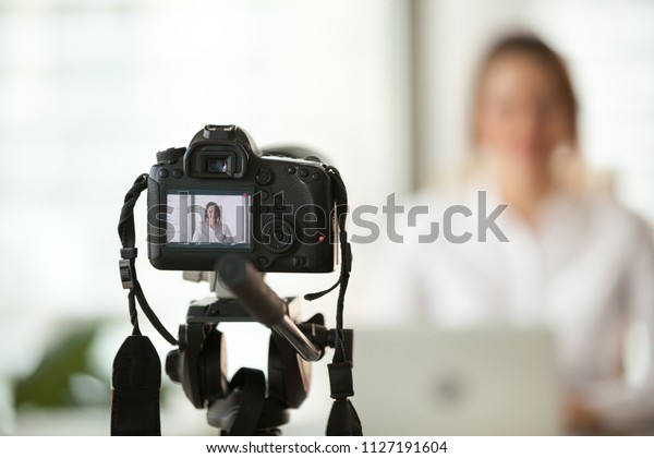Professional dslr digital camera filming live\
video blog interview or vlog of woman vlogger coach giving business\
class or presentation training people online, making videoblog and\
vlogging concept