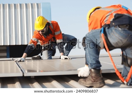Professional electric engineers survey and inspect solar panels installation on the factory metal sheet roof top, electric engineer team inspecting and check solar cell system.