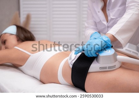 professional electrostimulation session, close up view o therapist applying EMS device on woman in modern clinic, muscle toning, body sculpting, fitness industry