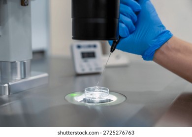 Professional embryologist using microscope for ICSI IVF procedure, microinjection of sperm into female egg cell in fertility clinic laboratory for assisted reproduction, human artificial insemination.