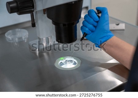 Professional embryologist using microscope for ICSI IVF procedure, microinjection of sperm into female egg cell in fertility clinic laboratory for assisted reproduction, human artificial insemination.