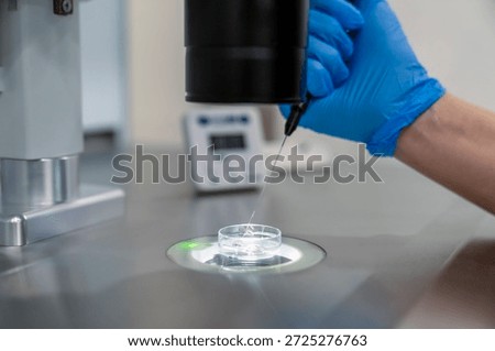 Professional embryologist using microscope for ICSI IVF procedure, microinjection of sperm into female egg cell in fertility clinic laboratory for assisted reproduction, human artificial insemination.