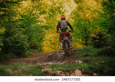 Professional enduro bike rider on action, dirt ride on the muddy road. Motocross sport. - Powered by Shutterstock