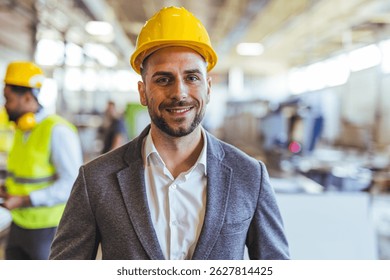 Professional engineer in a construction setting, wearing a hard hat and suit, showcasing confidence and leadership. The workplace background emphasizes an industrial and professional environment.