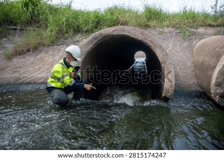 Professional Engineer Inspecting Drainage Pipe for Water Management Infrastructure Assessment