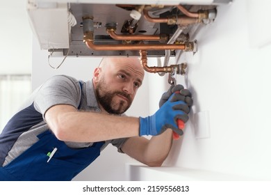 Professional Engineer Installing A Natural Gas Boiler At Home, He Is Checking The Pipes