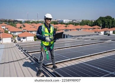 Professional engineer work to maintenance of photovoltaic panel system. Attractive technician worker working on roof inspect and check solar cell panels equipment box at solar cell field during sunset - Shutterstock ID 2258998907