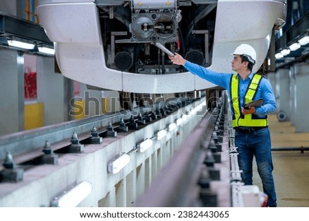 Professional engineer worker hold tablet and check or maintenance front part of electrical or metro tain in factory workplace.