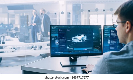 Professional Engineer Works on a Computer with a 3D CAD Software and Tests the Electric Car Chassis Prototype with Wheels, Batteries and Engine Standing in a High Tech Development Laboratory. - Shutterstock ID 1489717877