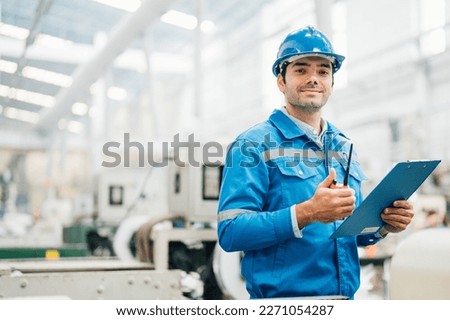 Professional Engineering of modern factory checking  to automatic machinery. Engineering with clipboard Programmable Logic Controller to manage large machine working full automatic.