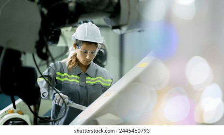 Professional engineering, worker, woman Quality control, maintenance, check in factory, Workshop for factory operators, Robotics engineer Female worker in a modern automotive manufacturing plant. - Powered by Shutterstock