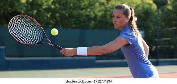 Professional equipped female tennis player beating hard the tennis ball with racquet - Powered by Shutterstock