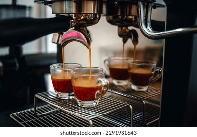 Professional espresso machine while preparing two espressos shot in a coffee shop. Close-up of espresso pouring from the coffee machine