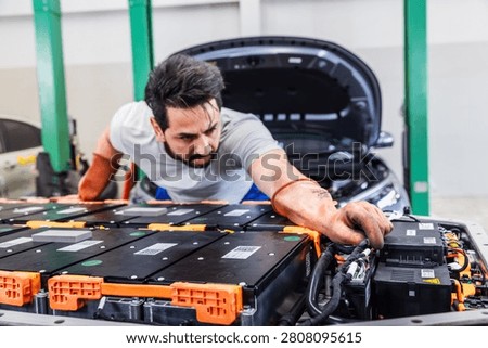 Professional EV technician inspecting high-voltage battery electrical connections inside a modern electric vehicle service center. The technician carefully checks battery connectors and wiring to ensure safety, reliability, and optimal system performance. Concept of electric vehicle diagnostics, battery maintenance, preventive inspection, automotive engineering, and sustainable mobility.