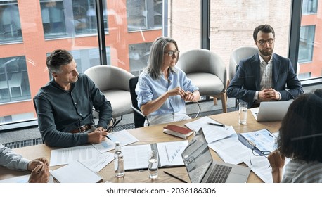 Professional Executive Businesspeople Discuss Corporation Project Planning Sit At Meeting Table In Boardroom. Company Managers Brainstorm Financial Plan Working Together With Document Papers In Office