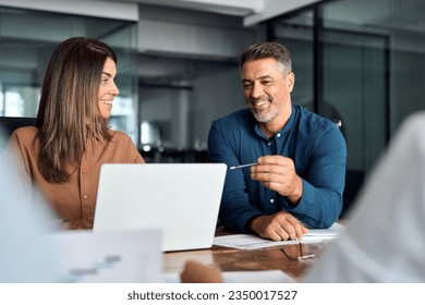 Professional executive team working at meeting in office. Older business man manager leader talking to board people consulting partners investors discussing digital project management in teamwork. - Powered by Shutterstock