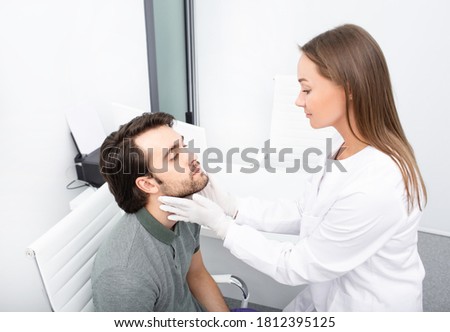 Professional experience endocrinologist checking thyroid gland of handsome man patient by palpation. An adult man has enlarged thyroid gland and hormones are not normal