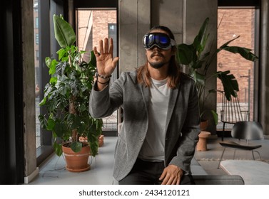 A professional explores the potential of spatial computing with the augmented reality headset in a modern office setting, blending the virtual with the real.