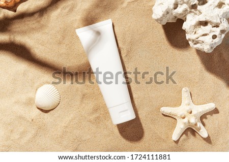 Professional face skincare. Unbranded flacon with moisturizing liquid. Cream or lotion. Mockup style. Summer decorations, seashell and starfish, sand background. Beauty concept