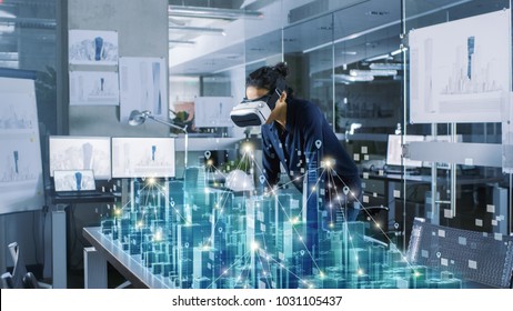 Professional Female Architect Wearing Makes Gestures with Augmented Reality Headset, Shows Statistics for 3D City Model. High Tech Office Use Virtual Reality Modeling Software Application.