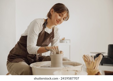 Professional female artisan shaping clay bowl in pottery studio. Ceramics art concept - Powered by Shutterstock