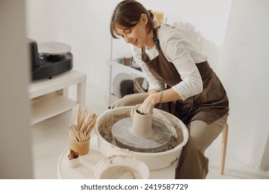 Professional female artisan shaping clay bowl in pottery studio. Ceramics art concept - Powered by Shutterstock