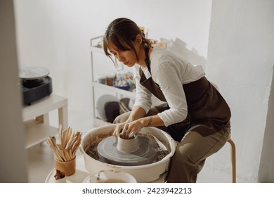 Professional female artisan shaping clay bowl in pottery studio. Ceramics art concept - Powered by Shutterstock