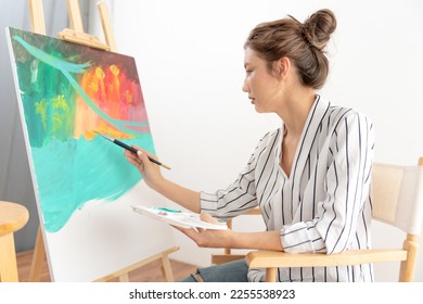 Professional female artist girl use paintbrush in abstract art for create masterpiece. painter paint with watercolors or oil in studio house. beautiful woman enjoy painting as hobby. work recreation - Shutterstock ID 2255538923