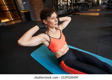 Professional Female Athlete Doing Ab Exercise On Gym Floor