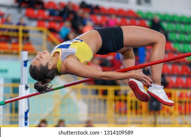 Professional female athlete jumping over bar in high jump competition - Powered by Shutterstock