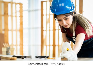 Professional Female Carpenter Working With Machinist Square To Measure Of Wood In The Wood Workshop