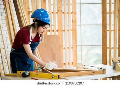 Professional Female Carpenter Working With Machinist Square To Measure Of Wood In The Wood Workshop