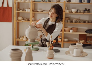 Professional female ceramist work with unfired clay vase in pottery studio. High quality photo - Powered by Shutterstock