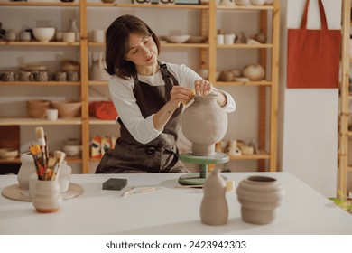 Professional female ceramist work with unfired clay vase in pottery studio. High quality photo - Powered by Shutterstock