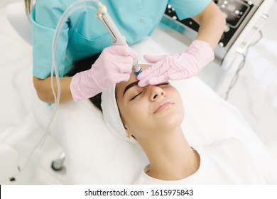Professional female cosmetologist doing hydrafacial procedure in Cosmetology clinic. Doctor use hydra vacuum cleaner. Rejuvenation And Hydratation. Cosmetology - Shutterstock ID 1615975843