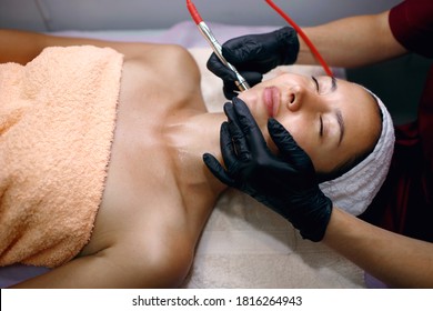 A Professional Female Cosmetologist Perform A Hydrafacial Procedure In A Cosmetology Clinic. The Doctor Cleans The Pores Of The Face With A Vacuum. Rejuvenation And Hydration In The Spa