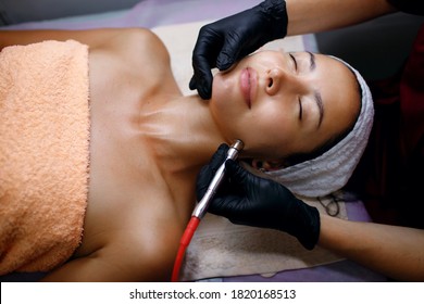 A Professional Female Cosmetologist Perform A Hydrafacial Procedure In A Cosmetology Clinic. The Doctor Cleans The Pores Of The Face With A Vacuum. Rejuvenation And Hydration In The Spa