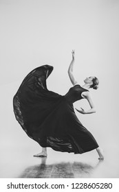 Professional Female Dancer In Black Dress Dancing Flamenco In Studio Isolated Background. Beautiful Young Woman Girl Posing Indoors Natural Light Black And White Copy Space Choreography Card Arts