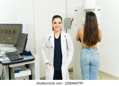 Professional Female Doctor Smiling While Doing A Mammogram To A Young Woman To Prevent Breast Cancer At The Medical Imaging Lab