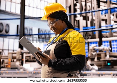 Professional female engineer using a tablet to monitor and control equipment at industrial facility. She is focusing on innovation, quality control and climate friendly technology.