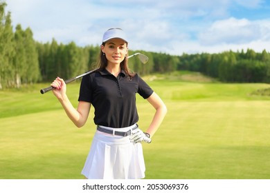 Professional female golfer holding golf club on field and looking away. Young woman standing on golf course on a sunny day. - Powered by Shutterstock