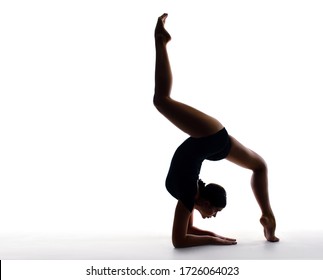 Professional female gymnast in sportswear performs a handstand. Training, elements of gymnastics, acrobatics on a white background. Sports motivation, stretching, splits. Banner for advertising