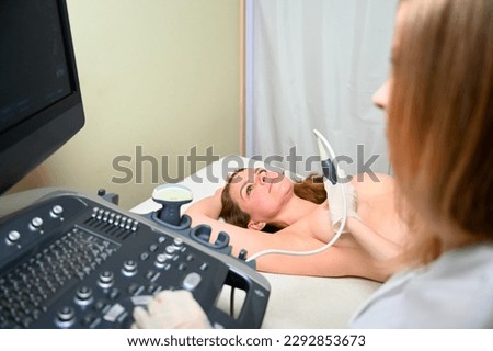 Professional female gynecologist performs an examination of the mammary glands using ultrasound scanner. Breast ultrasound examination. Prevention breast cancer. Screening after plastic surgery.
