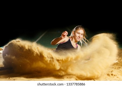 Professional female long jump athlete landing in sandpit - Powered by Shutterstock