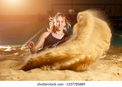 Professional female long jump athlete landing in sandpit - Powered by Shutterstock