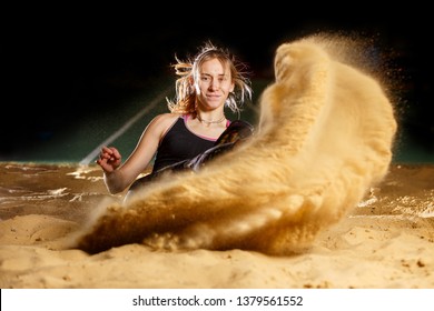 Professional Female Long Jump Athlete Landing In Sandpit