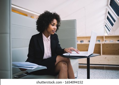 Professional Female Manager In Formal Wear Making Research Via Laptop Computer Reading News From Exchange, Confident African American Businesswoman Typing And Making Banking Online In Office
